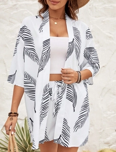 Detail of white three-piece resort set with black palm leaf print on cardigan and shorts