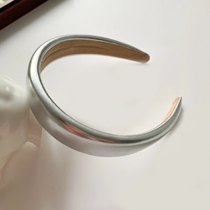 Close-up of padded silver PU leather headband with metallic laser finish and soft lining