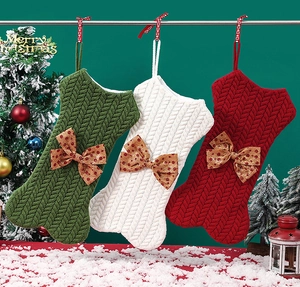 Detailed view of three knitted bone-shaped Christmas stockings with festive bows and dots