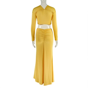 Rear view of yellow two-piece set featuring long sleeve crop top and ruched maxi skirt