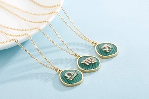 Detailed macro view of gold-framed malachite zodiac necklaces with crystal constellation symbols