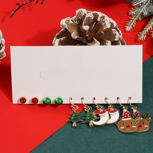 Detail of Christmas earring set with Santa, reindeer and tree motifs in festive arrangement