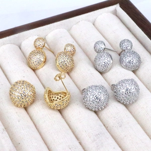 Gold and silver micro-paved geometric round stud earrings in a luxury jewelry box