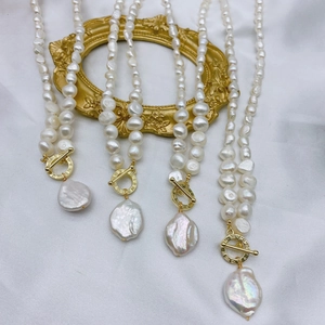 Elegant baroque freshwater pearl necklace with golden OT buckle on silk background