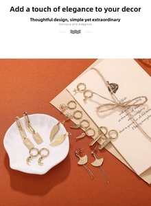 Collection of 18K gold plated stainless steel earrings with charms on a ceramic plate