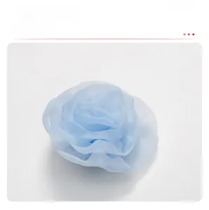 Detailed view of light blue multi-layered mesh gauze floral brooch and hair accessory