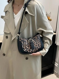 Fashionable leopard print underarm bag with black leather trim and silver buckle detail