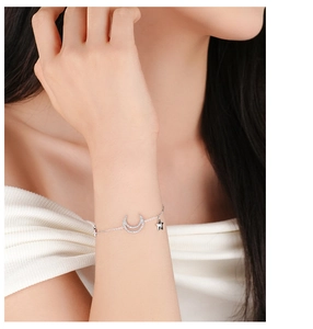 Macro detail of silver star and moon bracelet with zircon pendants worn on wrist