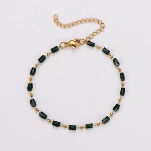 Detail of green emerald-cut beads and golden spacers on a stainless steel bracelet