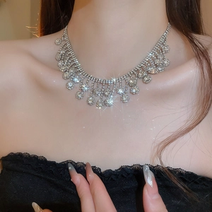 Close-up of sparkling rhinestone flower tassel necklace worn by a fashion model