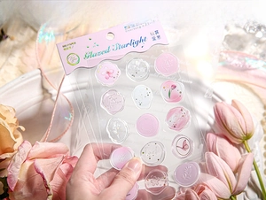 Close-up of pink Glazed Starlight resin wax seal stickers with floral and butterfly patterns