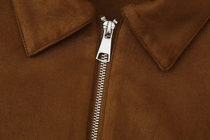 Close-up of the silver metal zipper and brown faux suede texture on this fashion jacket