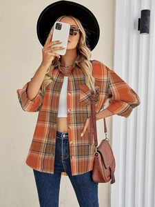 Close-up of orange plaid long sleeve shirt with front pocket and button collar