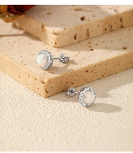 Macro detail of S925 silver opal stud earrings with white stone and zircon accents