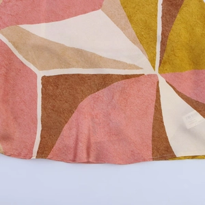 Détail macro du tissu à motif géométrique montrant la couture précise sur l'ourlet