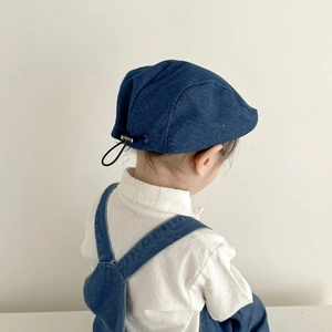 Detail of adjustable drawstring on navy denim kids beret with embroidery accents