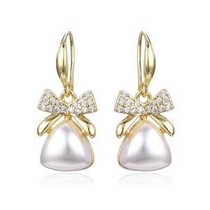 Elegant gold bow earrings with zircon stones and baroque teardrop pearls on white background