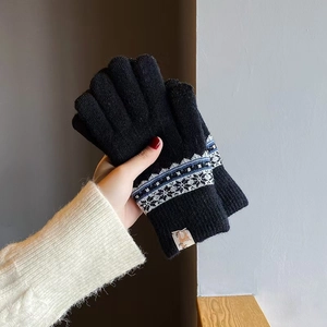 Close-up of black knitted gloves with snowflake jacquard patterns and thermal lining