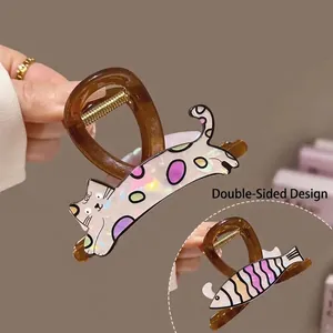 Cute double-sided claw clip featuring a polka dot cat and a purple striped fish