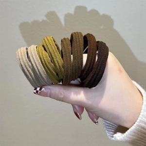 Detailed close-up of thick seamless elastic hair ties in earthy brown and beige tones