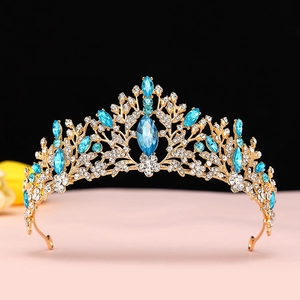 Macro detail of golden bridal crown featuring blue rhinestones and clear crystals