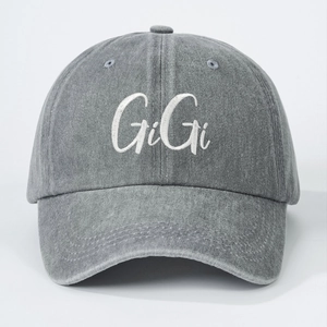 Detail of GIGI white embroidery on dark gray washed cotton denim baseball cap fabric