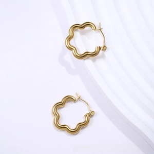 Detailed view of polished 18K gold-plated wave-shaped flower hoop earrings on white background