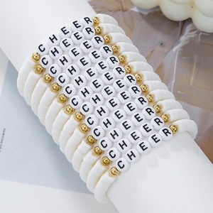 Detail of beaded friendship bracelets with white clay discs and gold CHEER letter beads