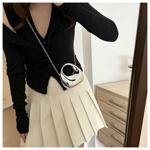 Sac bandoulière argenté métallique avec chaîne porté sur la tenue d'un mannequin