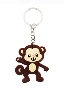 Macro detail of cartoon monkey PVC keychain with silver metal ring on white background