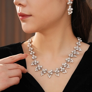 Détails de parure bijoux de mariée avec perles et strass sur collier et boucles
