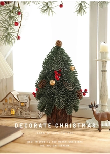 Mini frosted Christmas tree with red berries and pine cones on a rustic wooden base