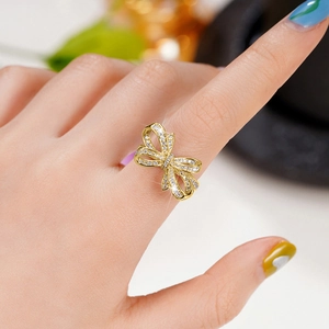 Gros plan sur une bague nœud dorée sertie de zircons blancs sur le doigt d'une femme