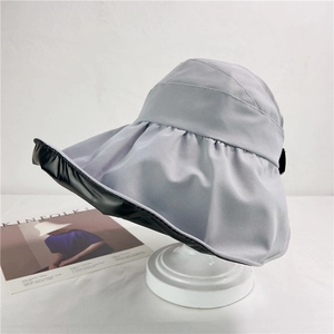 Close-up of wide brim sun hat with grey exterior and black UV lining on a stand
