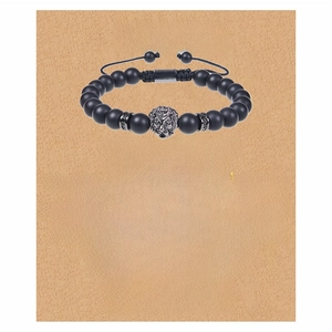 Macro detail of men's matte black stone bracelet with lion head charm on gift card