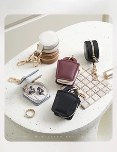 Miniature round and square jewelry boxes displayed on a white marble stone table