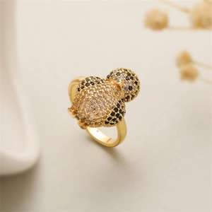Macro shot of gold-plated bee ring with white and black cubic zirconia stones
