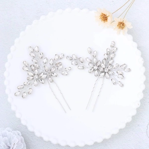 Detail of handmade bridal hair pins with silver metal leaves and sparkling rhinestones