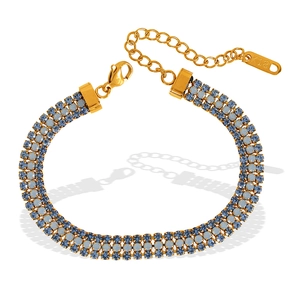 Bracelet doré à trois rangées avec cristaux de zircon bleu et bleu clair sur fond blanc