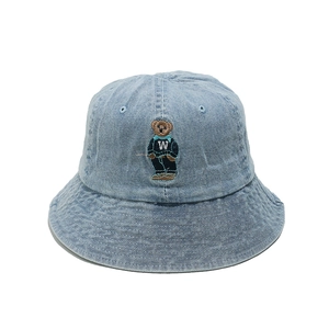 Close-up of teddy bear embroidery on a light blue washed denim bucket hat for women