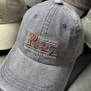 Detail of vintage washed canvas baseball cap featuring high-density letter R embroidery