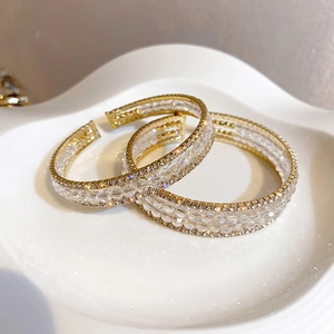 Detailed close-up of three-row gold-plated cuff bracelet with sparkling crystal rhinestones