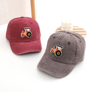 Detailed embroidery of an orange tractor on washed cotton baseball caps for kids