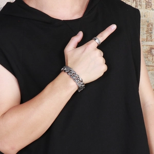 Detail of vintage carved totem bracelet and ring set on male model in black vest