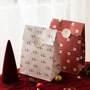 Christmas paper gift bags with colorful tree and Santa Claus patterns and gold stickers