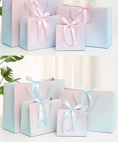 Detail of gradient gift bags with elegant ribbon bows and stylish typography design