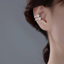 Detail of silver double-layered heart ear cuff featuring sparkling cubic zirconia stones