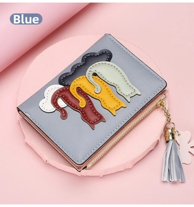 Close-up of blue leather wallet featuring colorful cat patchwork and tassel detail
