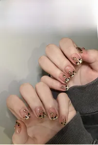 Macro detail of French leopard print press-on nails with gold leaf and GN series design