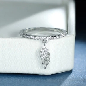 Macro shot of silver wing charm ring with sparkling cubic zirconia on jewelry box